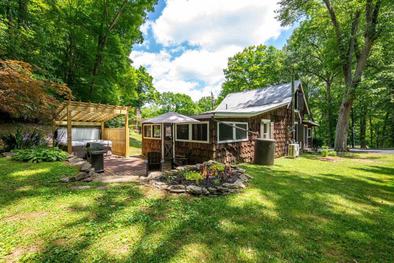 A rustic cabin with a covered porch and a small garden area.