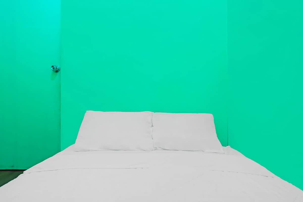 A bed in a room with green walls.