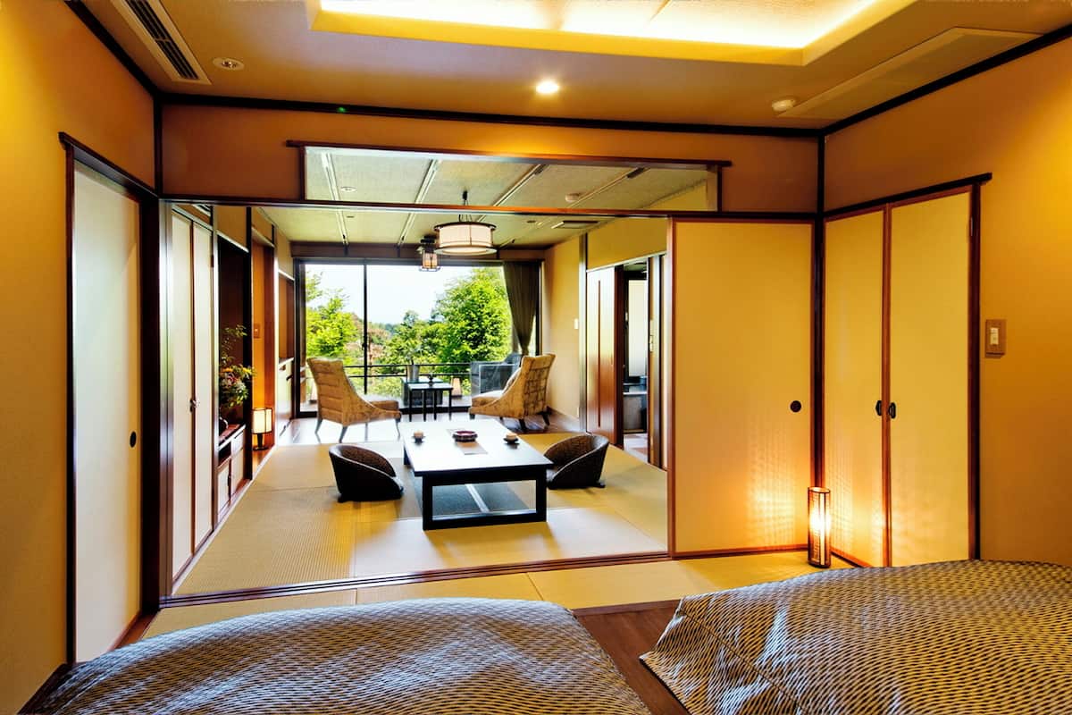 A traditional Japanese room with tatami flooring, a low table, and chairs.