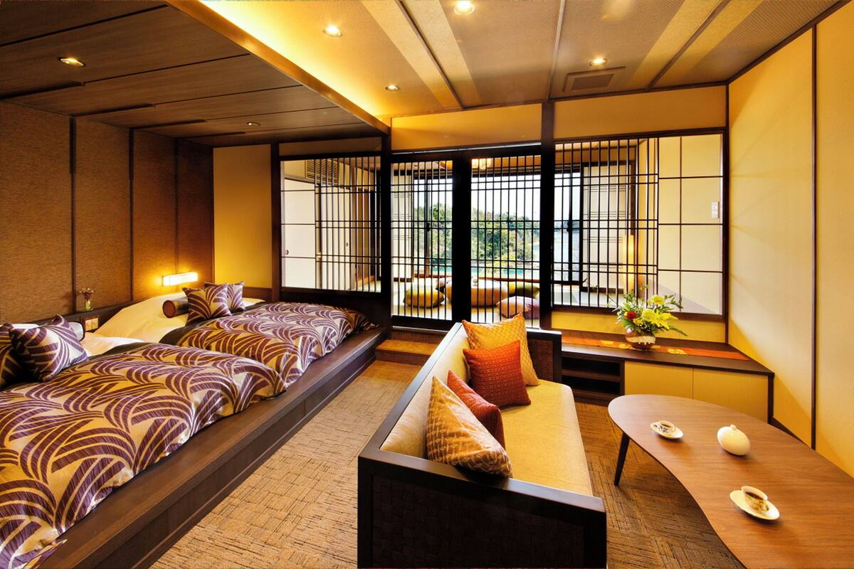 A traditional Japanese-style room with tatami flooring, a low table with a tea set, and a sofa with patterned cushions.