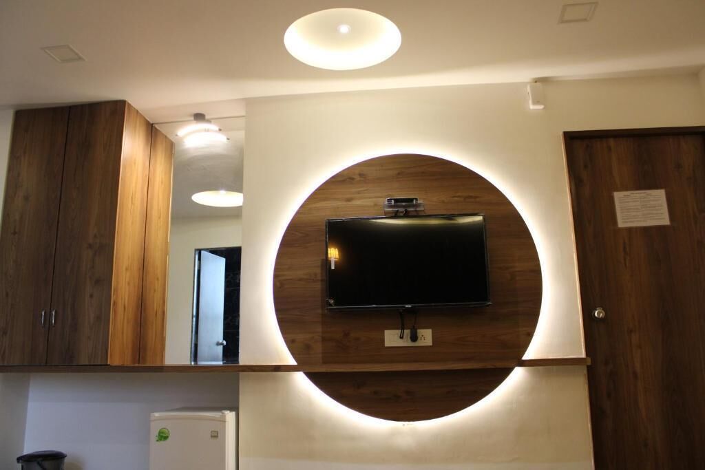 Una cocina moderna con armarios de madera, un televisor empotrado y una lámpara circular.