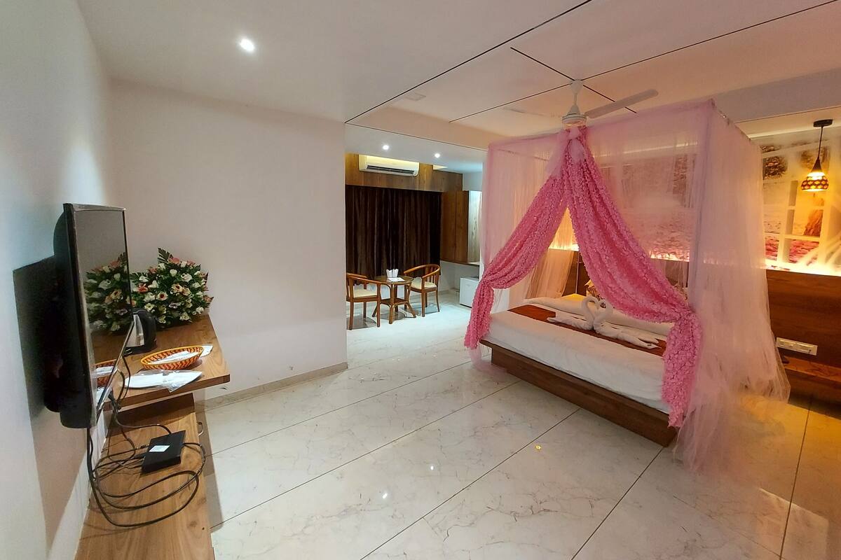 Ein Hotelzimmer mit Bett, Fernseher, Schreibtisch und Stuhl.