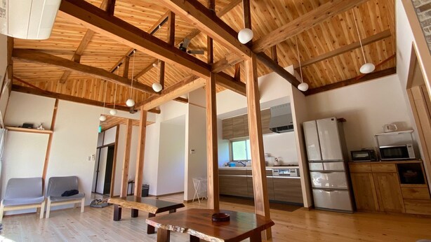 A spacious living area with wooden beams, a kitchen with modern appliances, and a dining table. - Sasayakana Ouchi S Nogi (Futtsu)