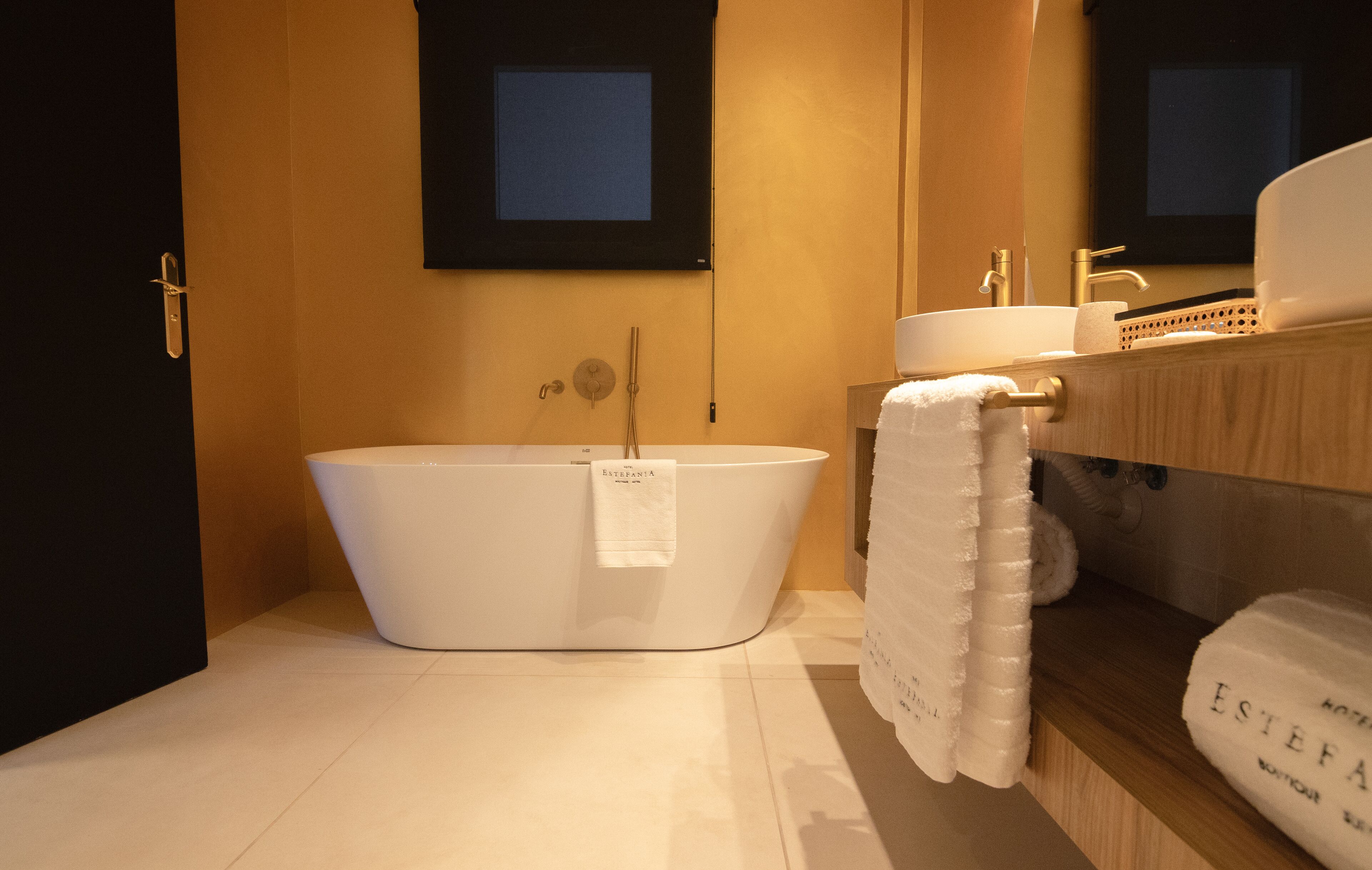 A modern bathroom with a freestanding bathtub, a sink, and a mirror.