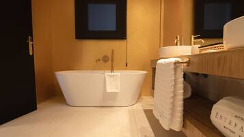 A modern bathroom with a freestanding bathtub, a sink, and a mirror.