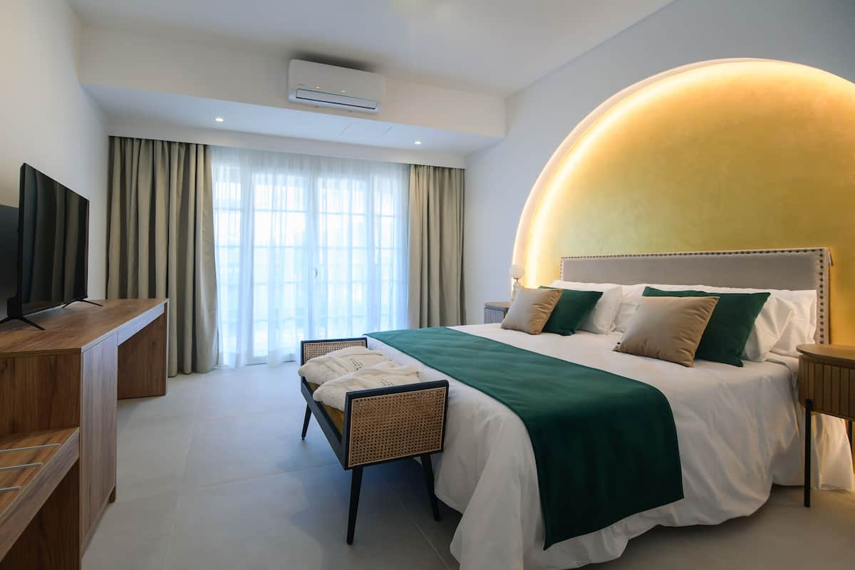 Een moderne hotelkamer met een groot bed, een flatscreen-tv, een bureau en een stoel.
