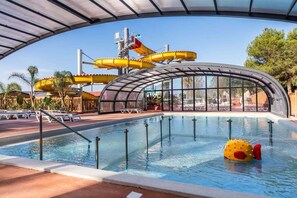 A swimming pool with a water slide and a sunshade structure. - Mobile Home 6 Couchages sur Camping 4 (Canet-en-Roussillon)