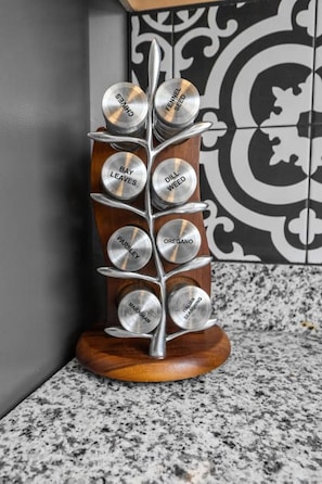 A spice rack with labeled containers for bay leaves, dill weed, parsley, oregano, and Italian seasoning.