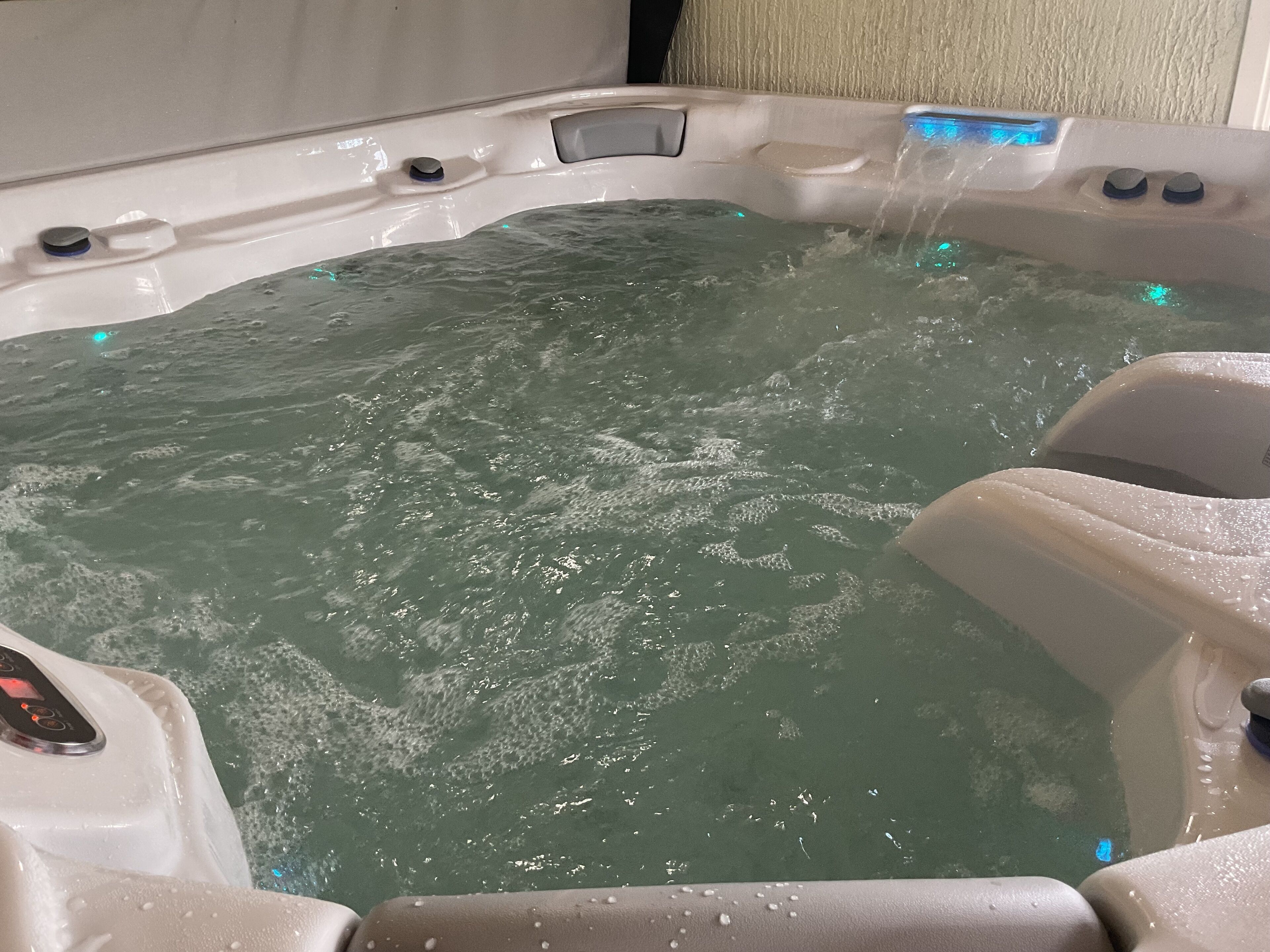 Un jacuzzi con chorros de agua, un panel de control y una zona de estar.