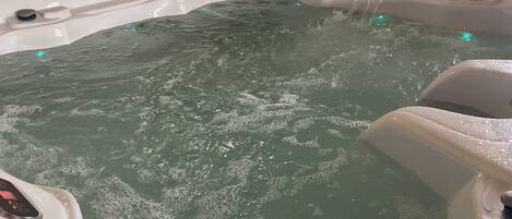 Un jacuzzi con chorros de agua, un panel de control y una zona de estar.