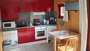 A compact kitchen with red cabinets, a microwave, a coffee maker, and a small oven. - Studio for 4, balcony, shared parking (Valloire)