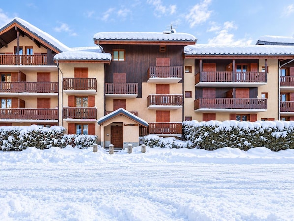 A multi-story hotel with balconies, wooden exterior, and snow-covered surroundings.