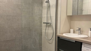 A modern bathroom with a shower, a sink, and a toilet.