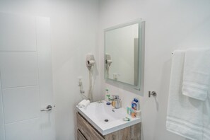 A bathroom with a white sink, a mirror, a towel rack, and a hairdryer. - FULLY REMODELED MODERN 1-BEDROOM APARTMENT in NOHO w/ PARKING & EV CHARGER p69 (NORTH HOLLYWOOD/LOS ANGELES)
