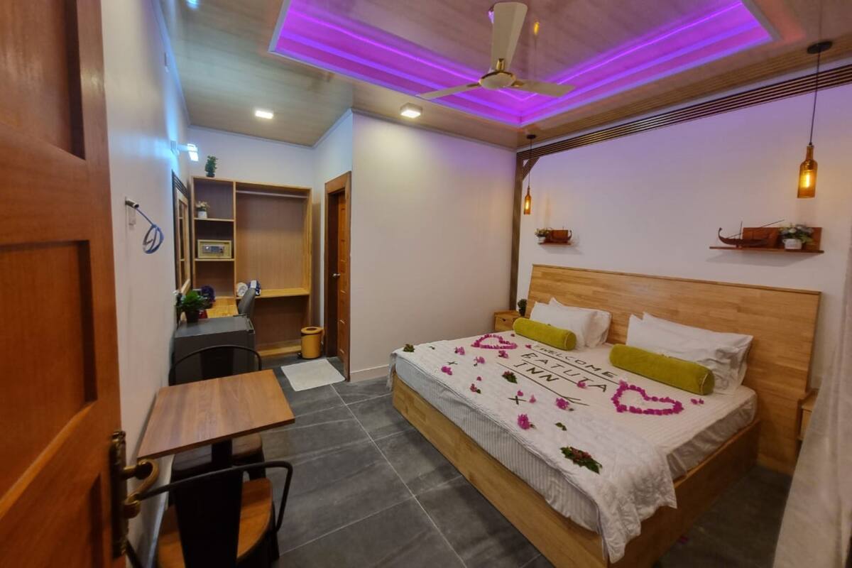 A bedroom with a bed, bedside tables, a desk, and a wardrobe.