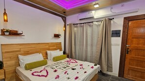 A neatly made bed with a welcome mat, a wooden headboard, and a ceiling fan. - Batuta Maldives Inn (Thulusdhoo Island)