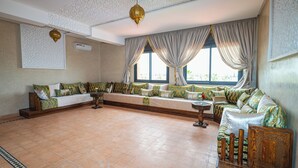 Amplia sala de estar con un ventanal, un conjunto de sofás, una mesita de centro y lámparas decorativas.