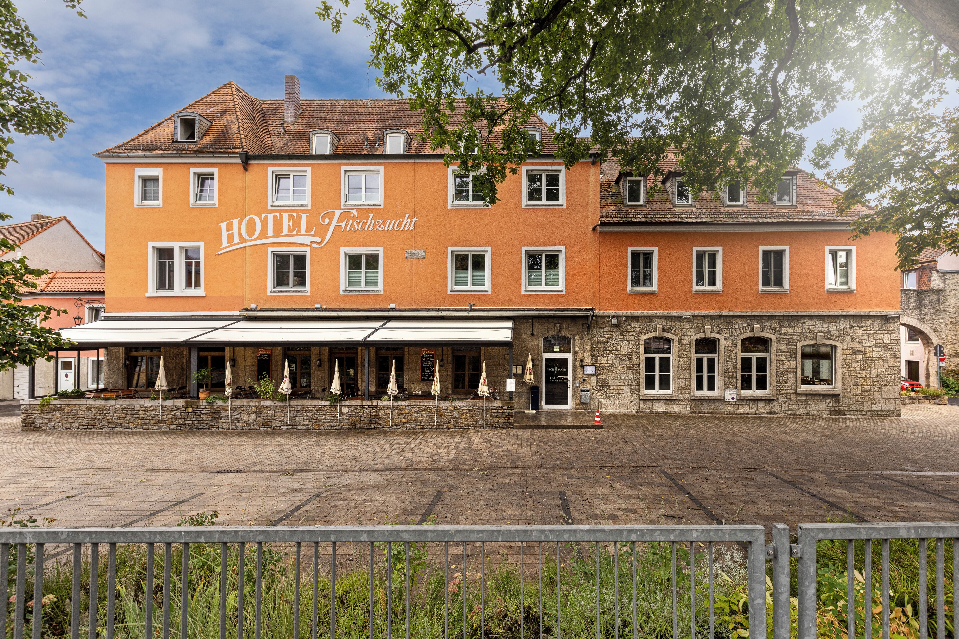 A hotel with a stone facade and a tiled roof.