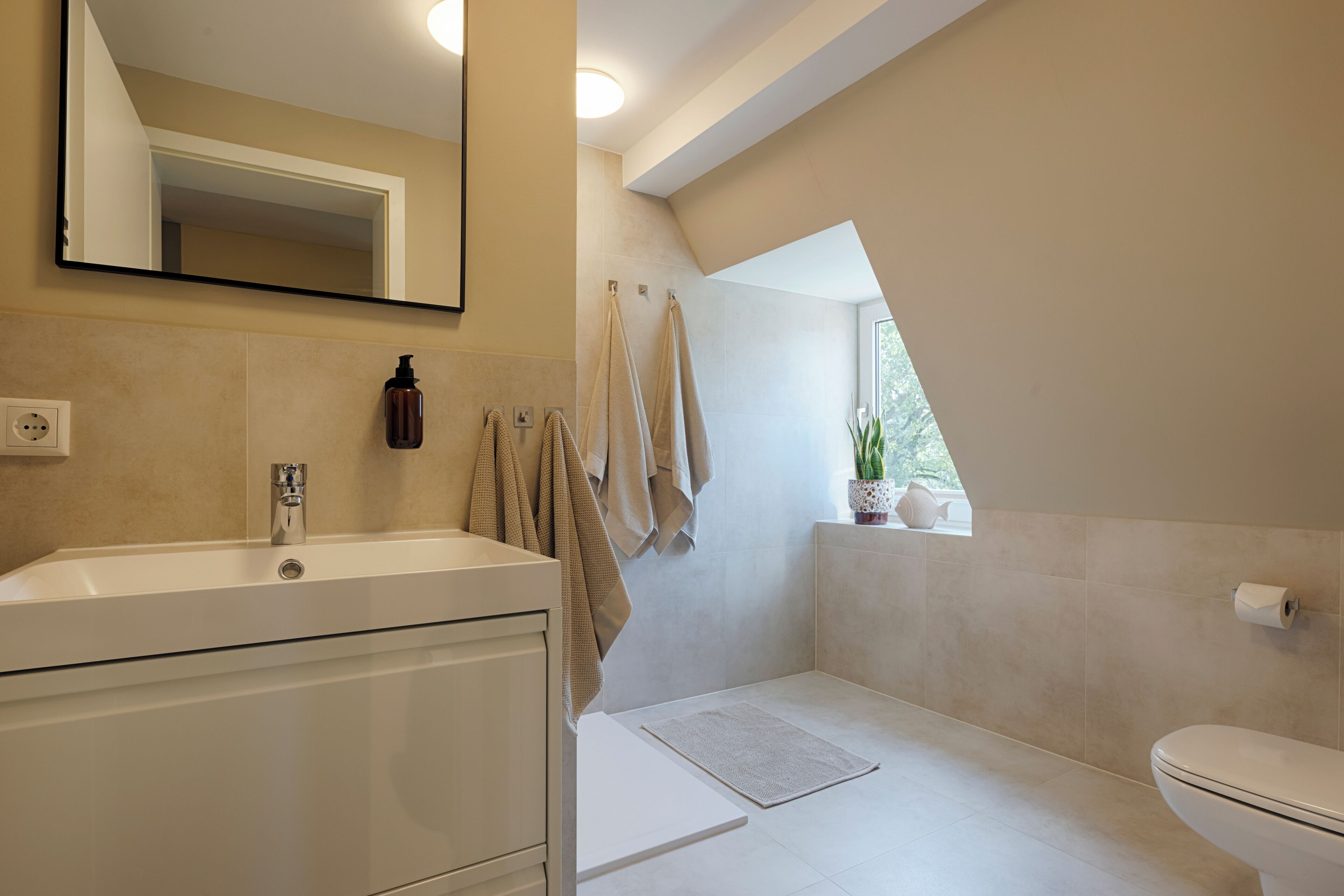 Une salle de bain moderne avec une baignoire, des toilettes et un grand miroir.