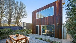 A modern two-story building with a wooden exterior and large sliding glass doors. - Silver Ball Retreat (Warrnambool)
