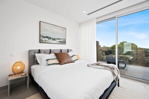 A modern bedroom with a large bed, a nightstand, a lamp, and a painting on the wall. - Casa Lux Aireys Inlet Retreat with Heated Pool Spa (Aireys Inlet)