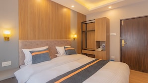 A modern hotel room with a large bed, wooden headboard, built-in shelving, and a wardrobe. - Aawas Boutique Hotel (Kathmandu)