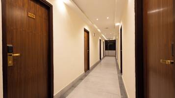 Un pasillo de hotel con puertas de madera, piso de baldosas y un cartel que indica la habitación número 109.