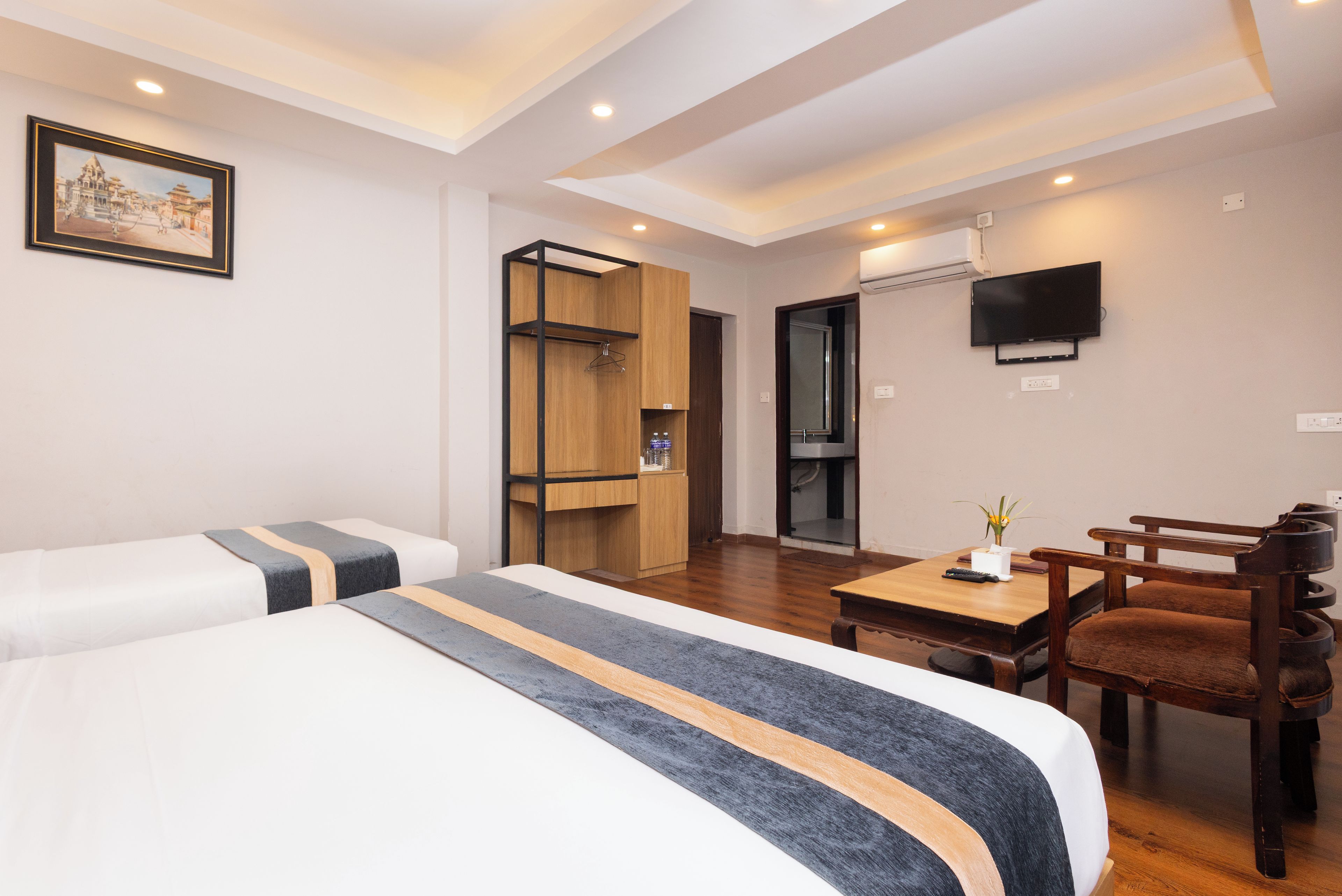 Een hotelkamer met een bed, een bureau, een stoel, een televisie en een kledingkast.