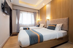 A hotel room with two beds, a television, a window with curtains, and a wooden accent wall. - Aawas Boutique Hotel - Central Thamel (Kathmandu)