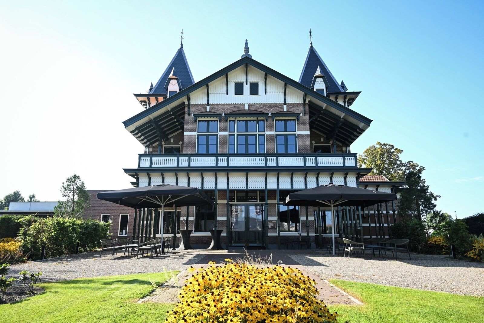 A large, two-story building with a symmetrical facade, featuring a central entrance flanked by two wings.