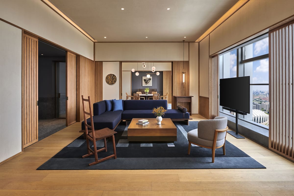A modern living room with a sectional sofa, a coffee table, and a TV.