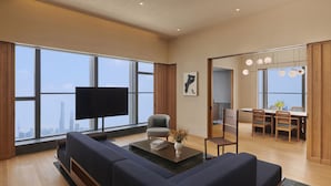 A modern living room with a large flat-screen TV, a sofa, a coffee table, and a dining area with wooden furniture. - Artyzen NEW BUND 31 Shanghai (Shanghai)