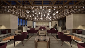 A modern hotel lobby with a high ceiling, multiple seating areas, and a central table. - Artyzen NEW BUND 31 Shanghai (Shanghai)
