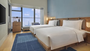 A modern hotel room with two beds, a large window offering a city view, a flat-screen TV, and a small desk area. - Artyzen NEW BUND 31 Shanghai (Shanghai)