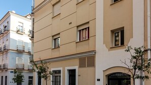 En byggnad med flera våningar, balkonger, en slät fasad och en dörr som är märkt med "1–2".