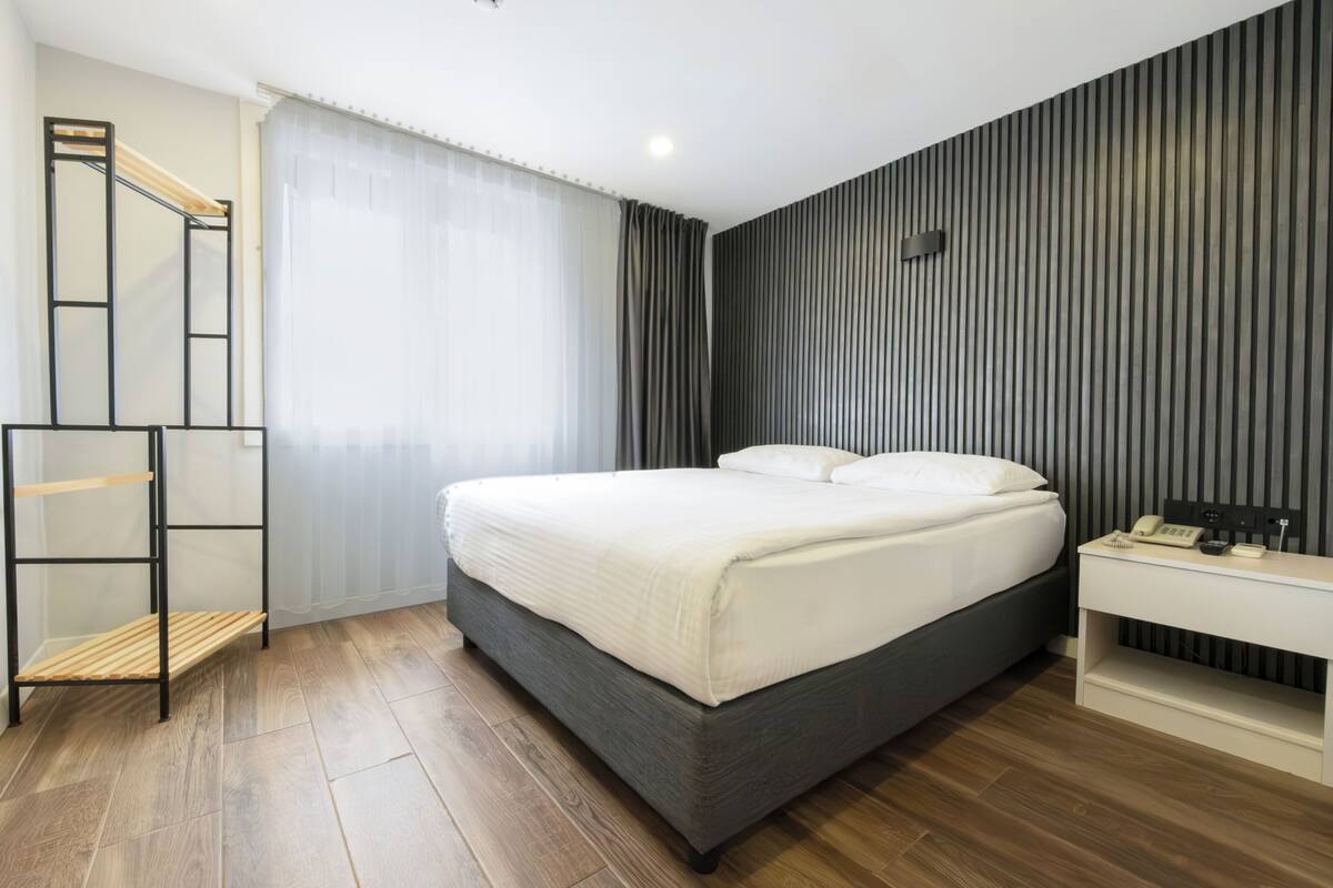A modern bedroom with a bed, bedside table, and a built-in shelf.