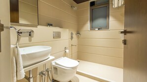 A modern bathroom with a sink, toilet, and shower.