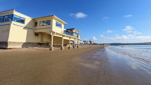 Een pand aan het strand met een ruime constructie, meerdere balkons en een overdekt terras.