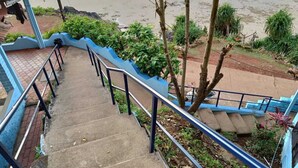 Eine Betonstairtreppe mit blauen Geländern führt zum Strand.