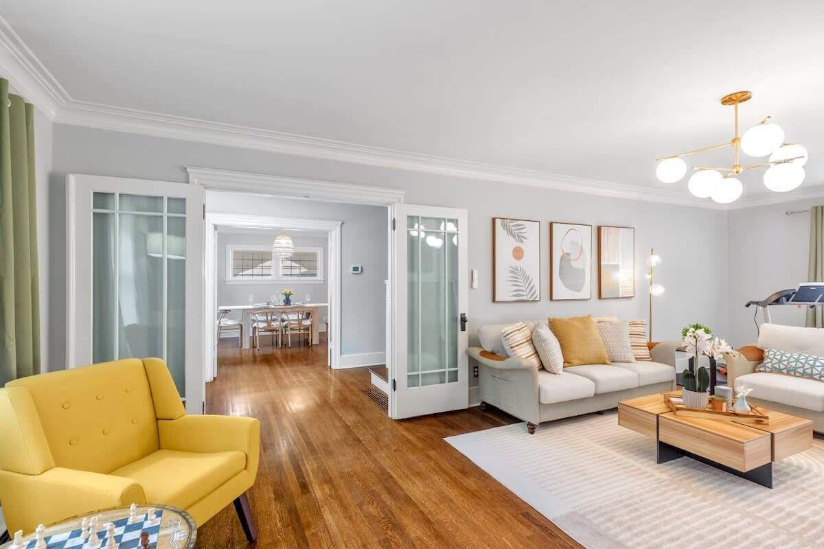 A modern living room with a yellow armchair, a white sofa, and a wooden coffee table.