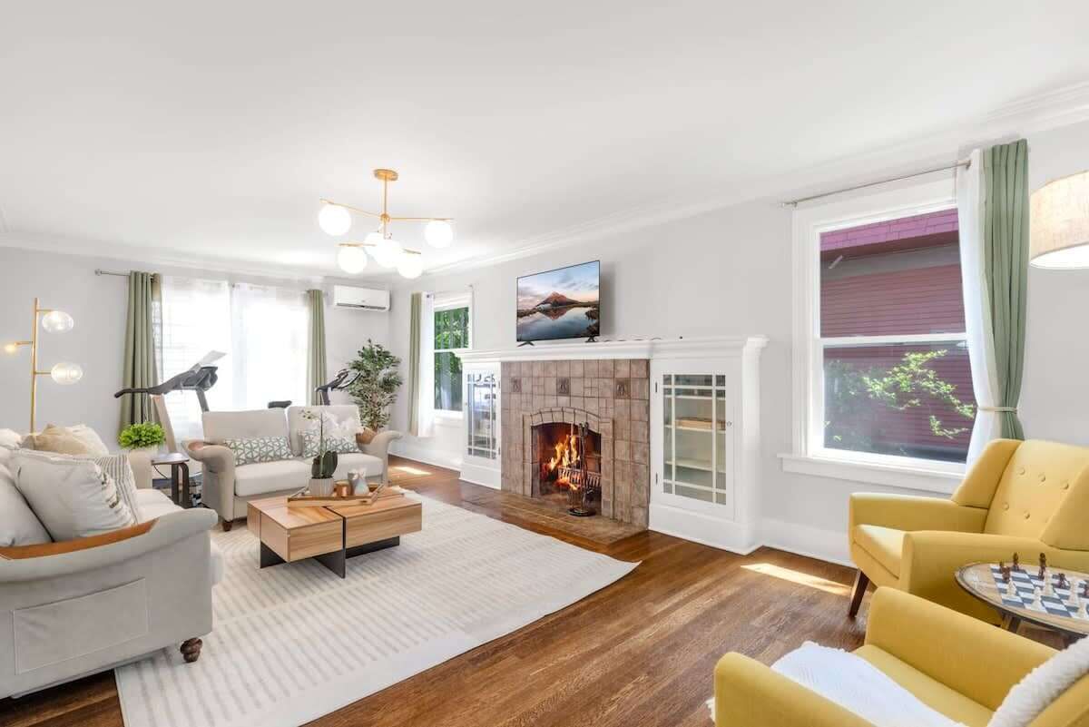 A modern living room with a fireplace, a sofa, a coffee table, and a television.