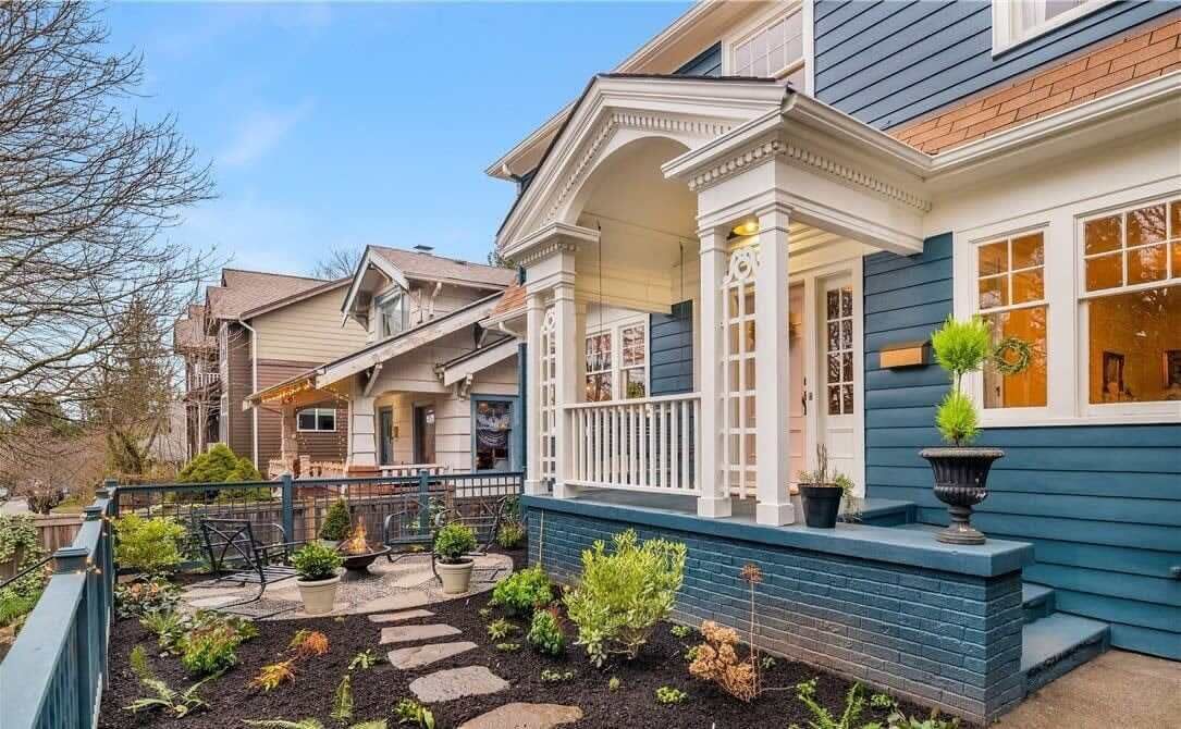 A residential house with a front porch, a small garden with stepping stones, and a blue exterior.