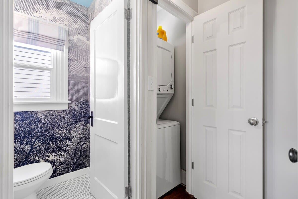 Une salle de bain avec des toilettes, une douche et une porte blanche.