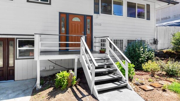 A two-story house with a front porch, a wooden door, and a number '22103' on the wall. - Bothell Family Friendly Modern Home, 2 AC, I405 (Bothell)