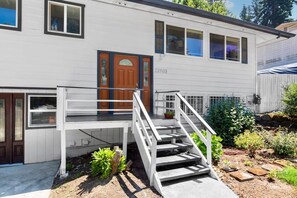 A two-story house with a front porch, a wooden door, and a number 22103 on the side.