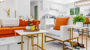 A modern living room with a sofa, coffee table, and a dining area with a table and chairs. - Bothell Family Friendly Modern Home, 2 AC, I405 (Bothell)