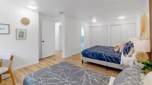 A modern bedroom with a bed, bedside table, lamp, and a chair. - Bothell Family Friendly Modern Home, 2 AC, I405 (Bothell)