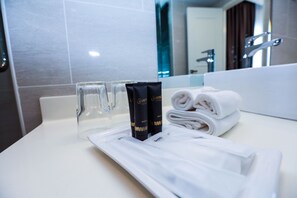 Clean bathroom with a modern design, featuring a sink, mirror, and toiletries.