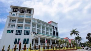 Um hotel com vários andares, um letreiro chamativo, varandas e bandeiras americanas.