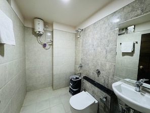 Et badeværelse med toilet, håndvask og bruser.